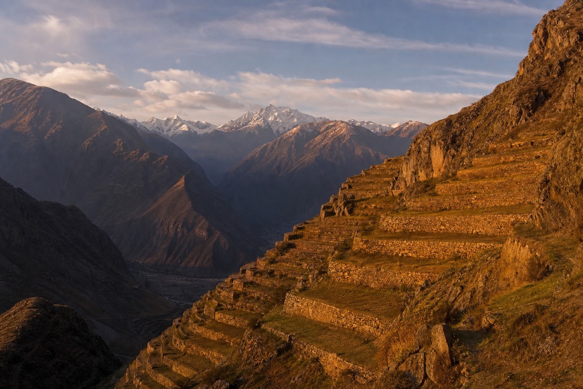 Terraced Andes mountains at golden hour above Peru's Sacred Valley, evocative of Bourdain's Peru episodes